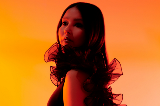MusicartistJemCassar-Daleystandsinshadowinfrontoforangelitbackground
