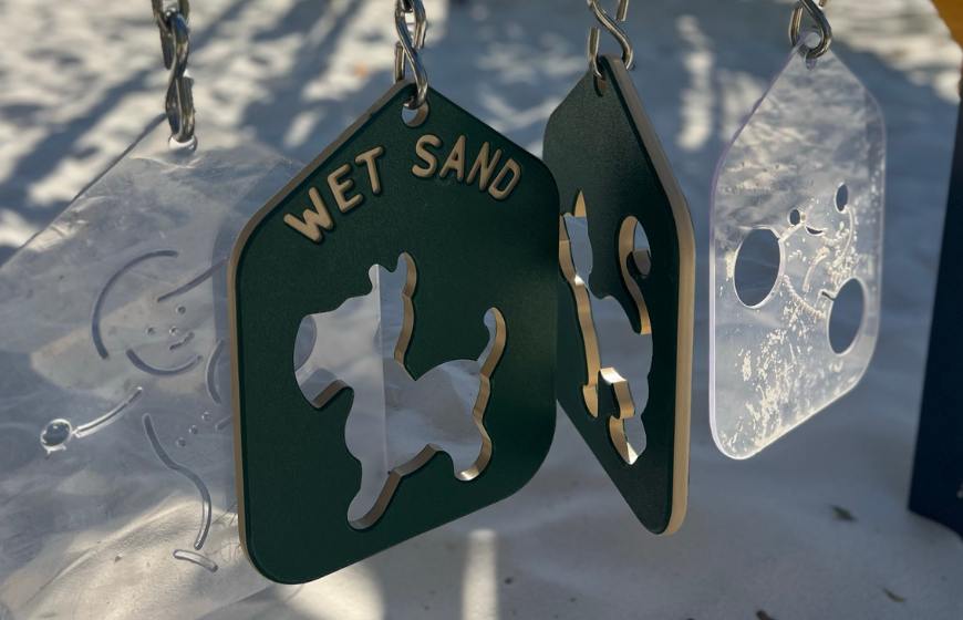 Outdoor playground toy with a cut out of a dog and the words wet sand