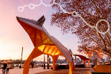 LargepublicartorangeandgreysculpturealongtheSwanRiveratsunset