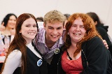 ThreeyoungpeoplestandingclosetogetherandsmilingataPerfectlyQueerevent