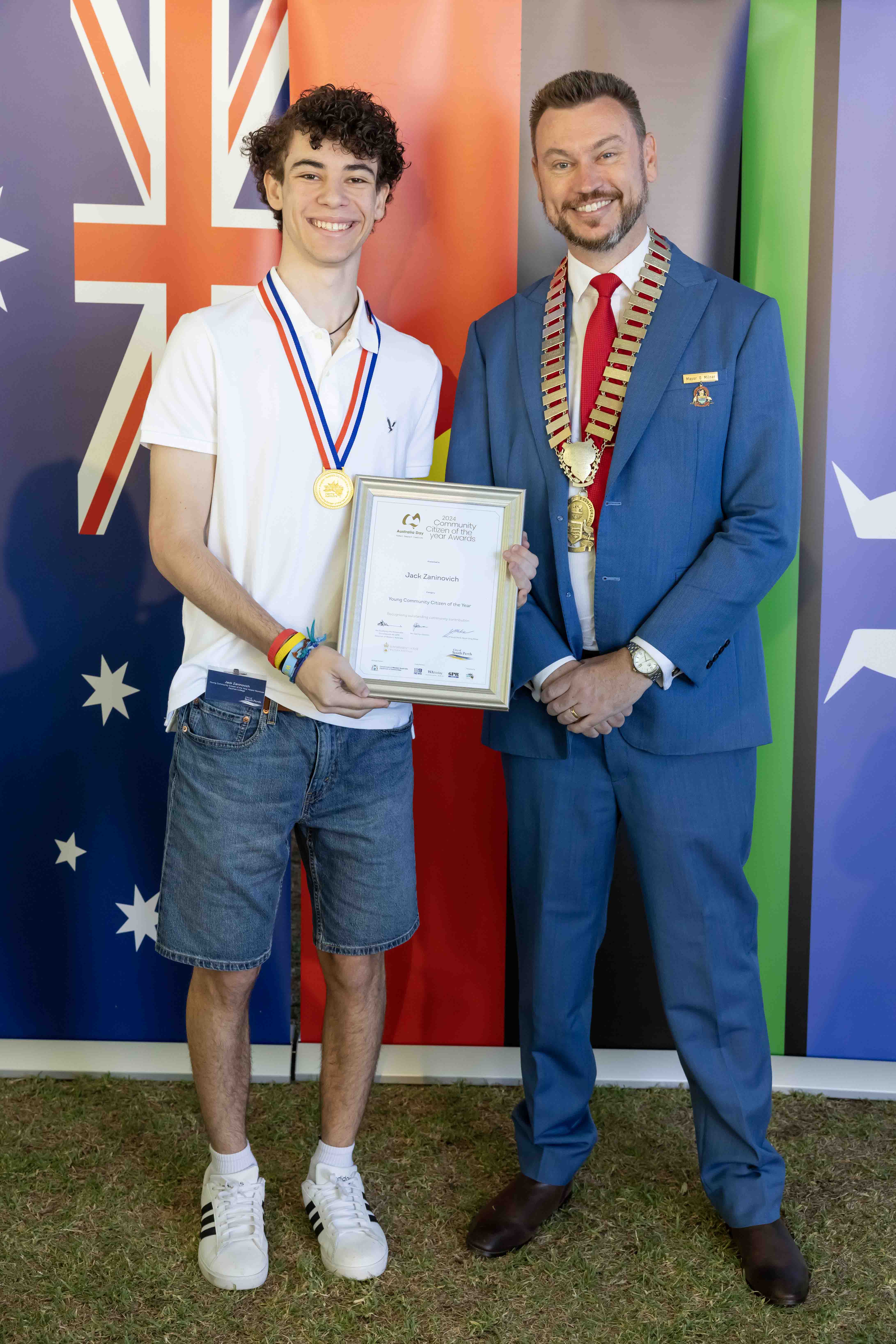 Two men smiling and holding a framed certificate.