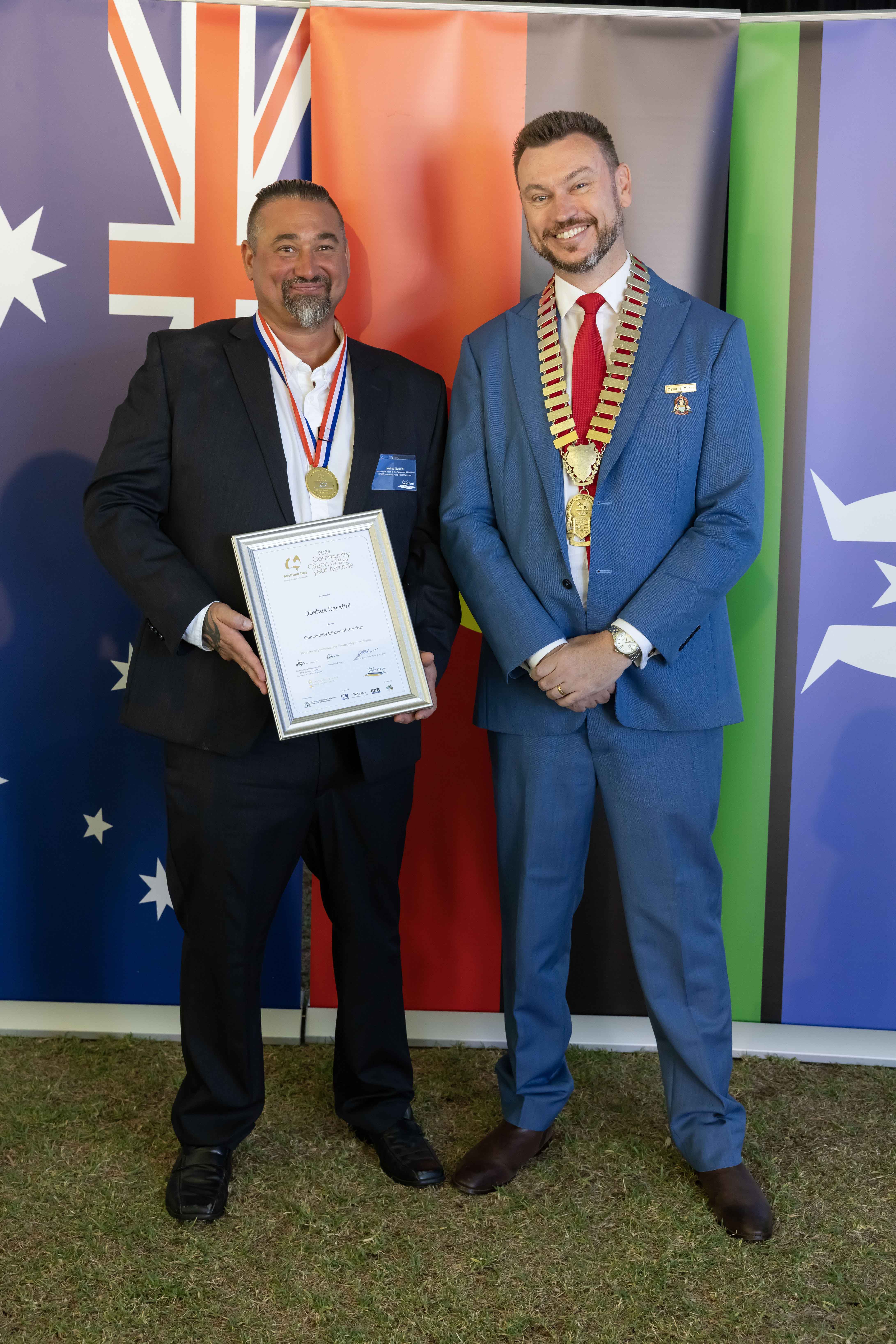 Two men smiling and holding a framed certificate.