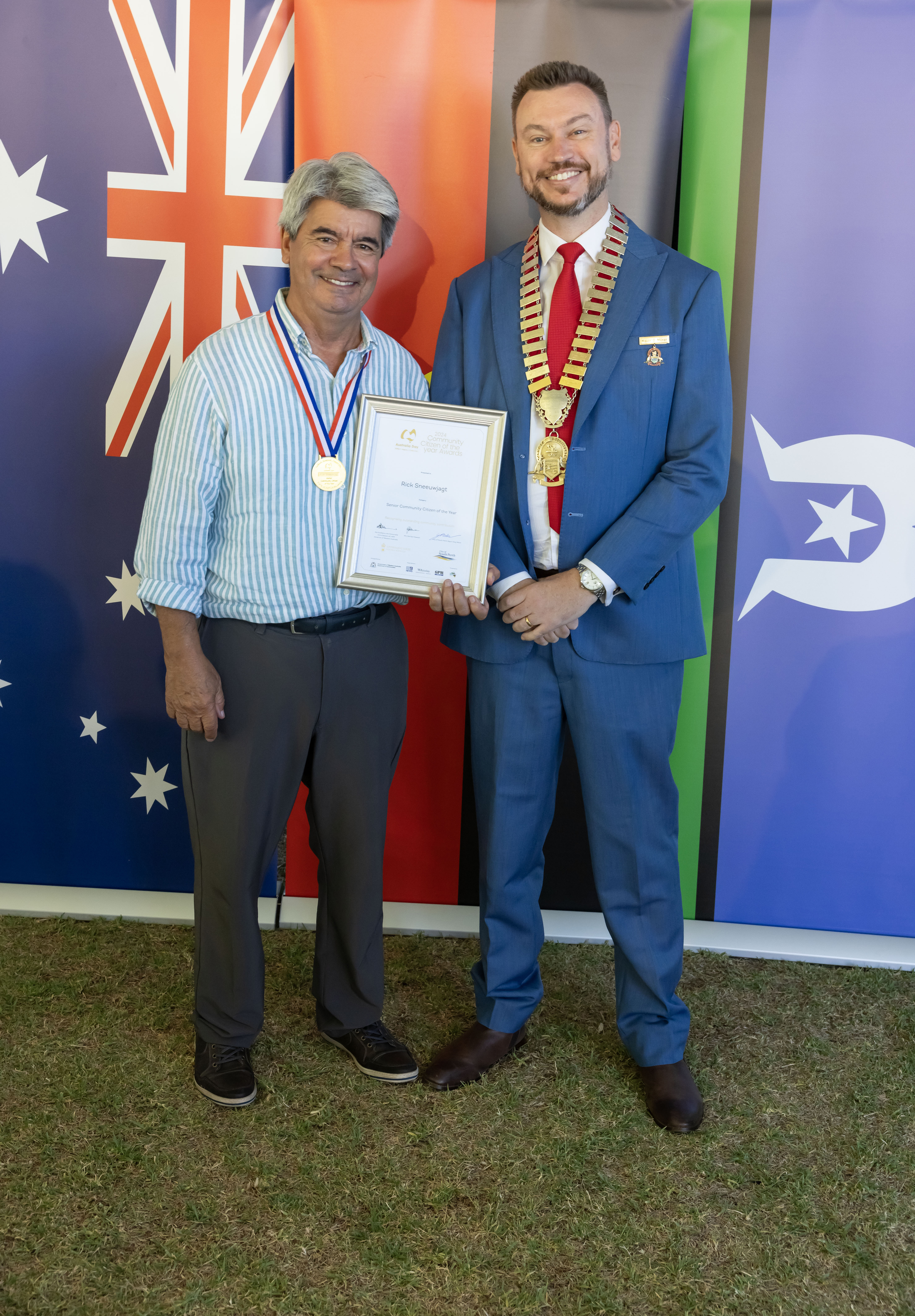Two men smiling and holding a framed certificate.