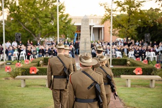 Peopleinuniformwalkingtowardsalargemonument
