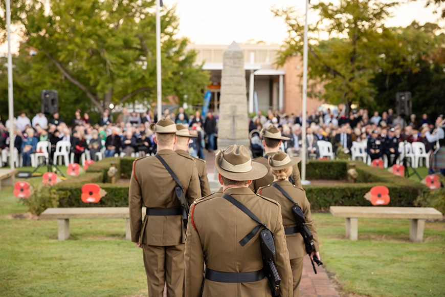Peopleinuniformwalkingtowardsalargemonument