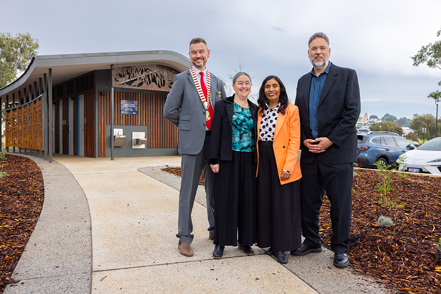 Four people standing in front of toilet block