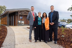Four people standing in front of toilet block