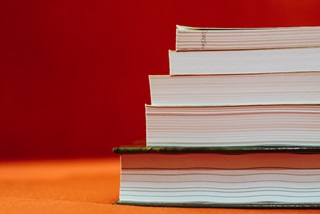 Apileofbookssetagainstaredbackdrop