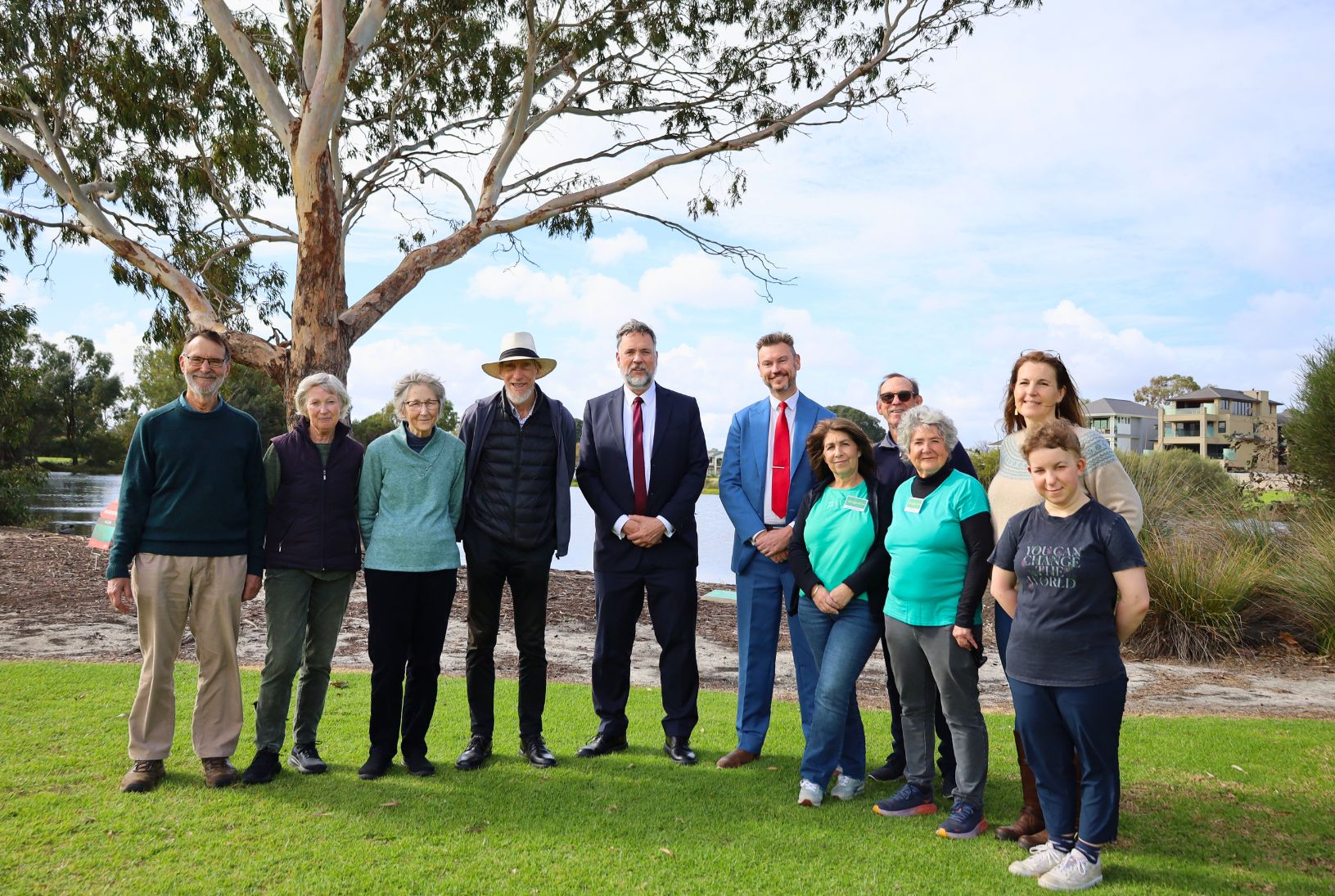 Group photo of Urban Greening grant recipients with Geoff Baker and Mayor Greg Milner standing beside Lake Douglas