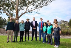 Group photo of Urban Greening grant recipients with Geoff Baker and Mayor Greg Milner standing beside Lake Douglas