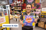 Image of man holding Shop Local sign at Preston St IGA