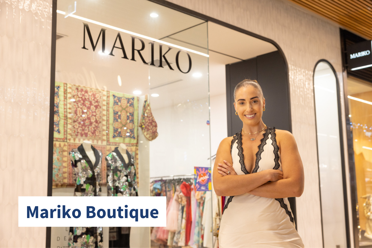 Owner of Mariko Boutique smiling at camera outside store