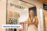 Owner of Mariko Boutique smiling at camera outside store