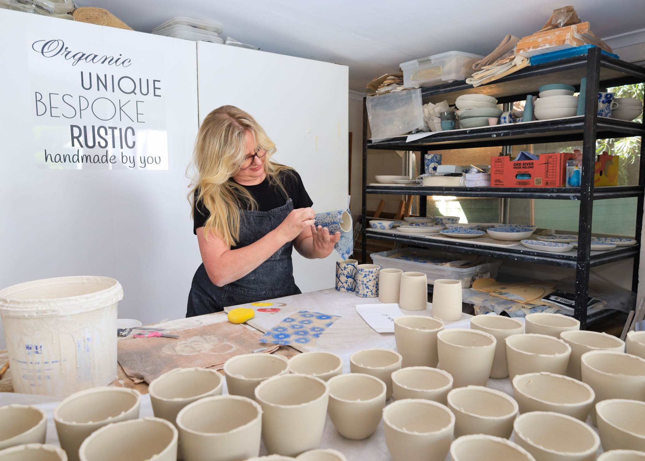 Woman crafts ceramic cup at artist studio