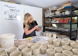 Woman crafts ceramic cup at artist studio