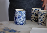 picture of a ceramic cup without a handle and a blue pattern on it