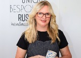 Picture of a woman holding a ceramic cup smiling to camera