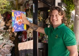Man applies sticker saying Shop Local South Perth to front window of gift shop