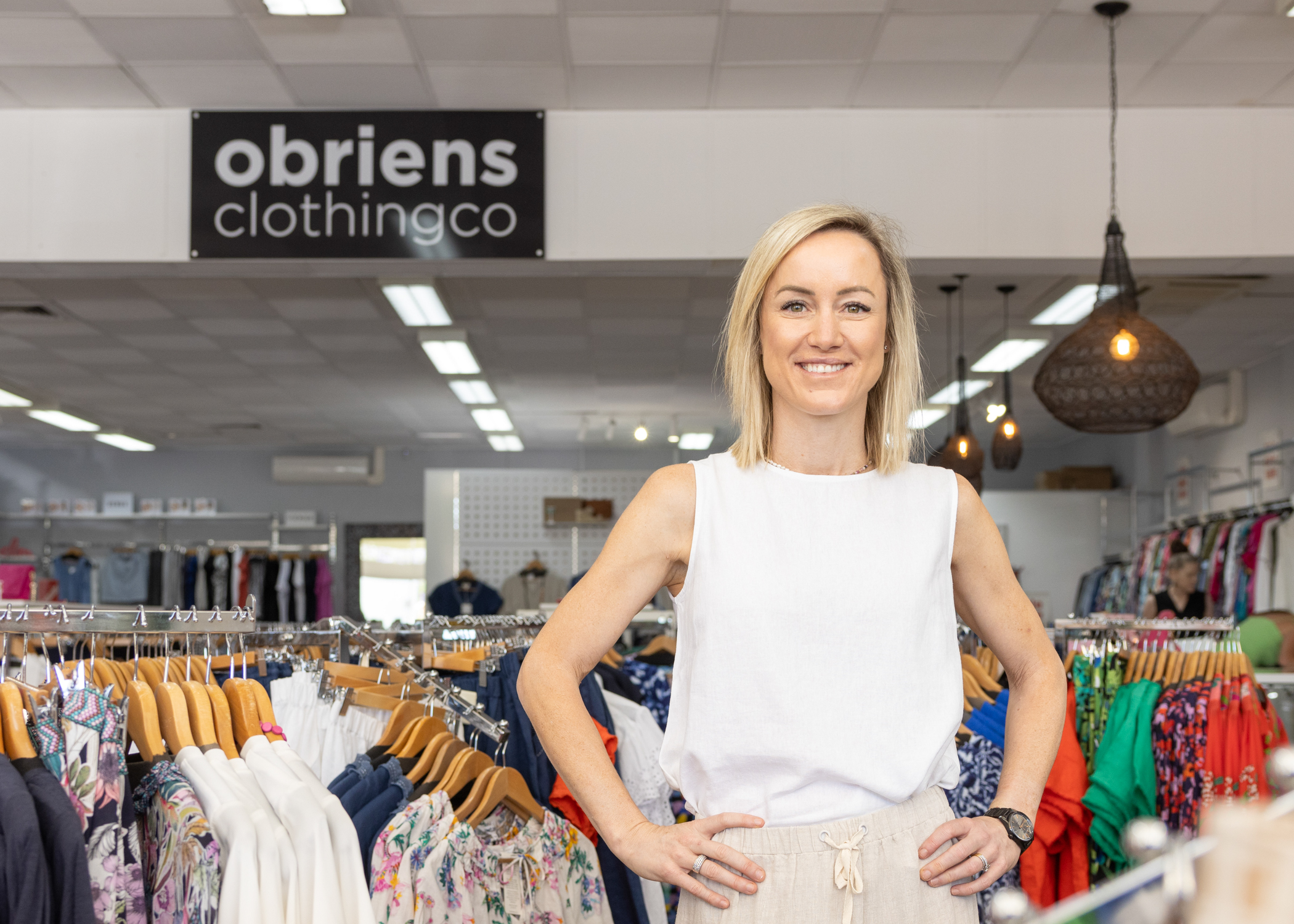 Person stands in front of a sign saying "obriens clothing co" in a clothing store