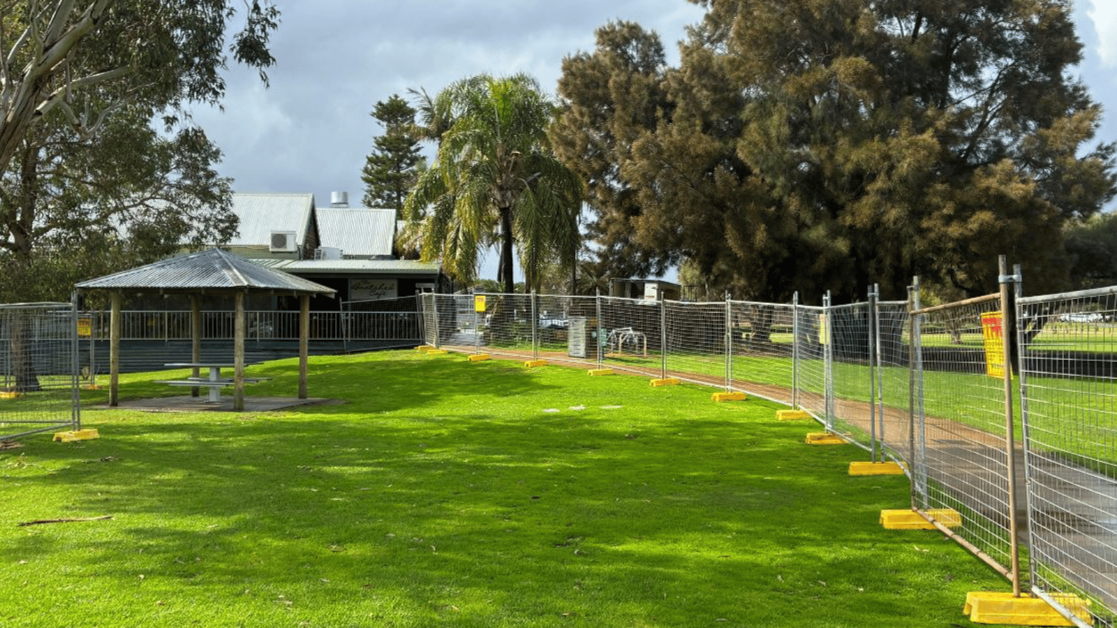 Temporary construction fencing on grassed area next to footpath