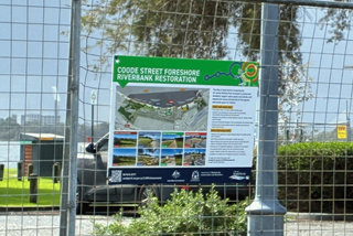 Signontemporaryconstructionfencinginfrontofpark