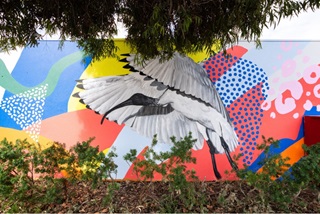 Awallmuralofanibiswithabackgroundofabstractcoloursandpatterns