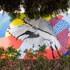 A wall mural of an ibis with a background of abstract colours and patterns