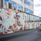 A wall mural with white horses and people mounted on them.