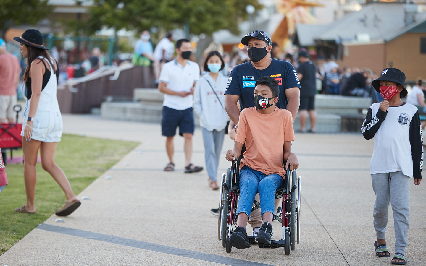 People and person using a wheelchair on footpath