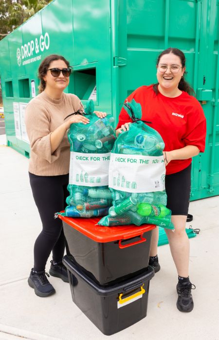 Two young women with containers at the Drop & Go Point