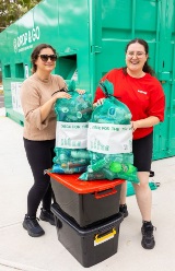 Two young women with containers at the Drop & Go Point