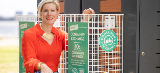 woman poses next to a container exchange bin