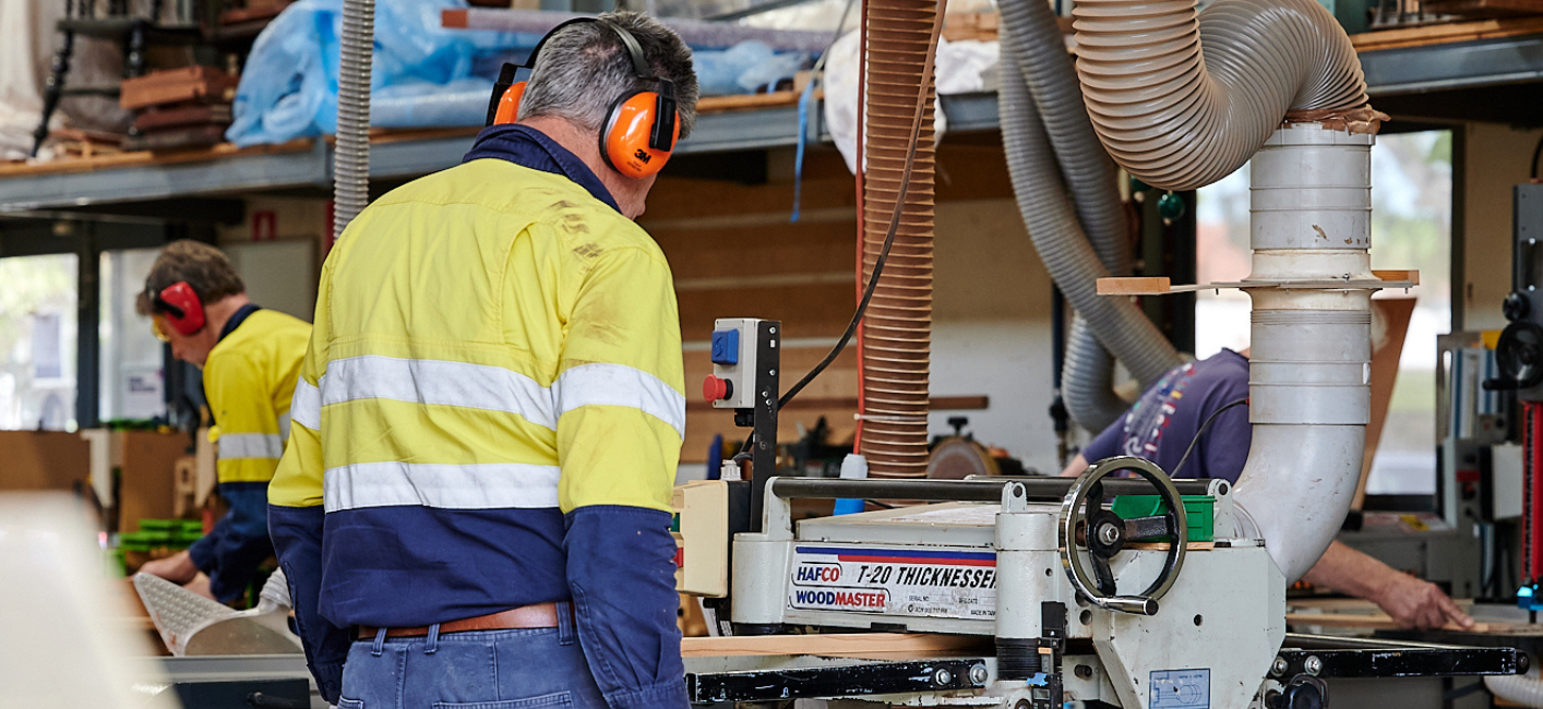 man wearing earphones working in a garage