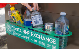 Handdropsbottlesintoacontainerexchangebin