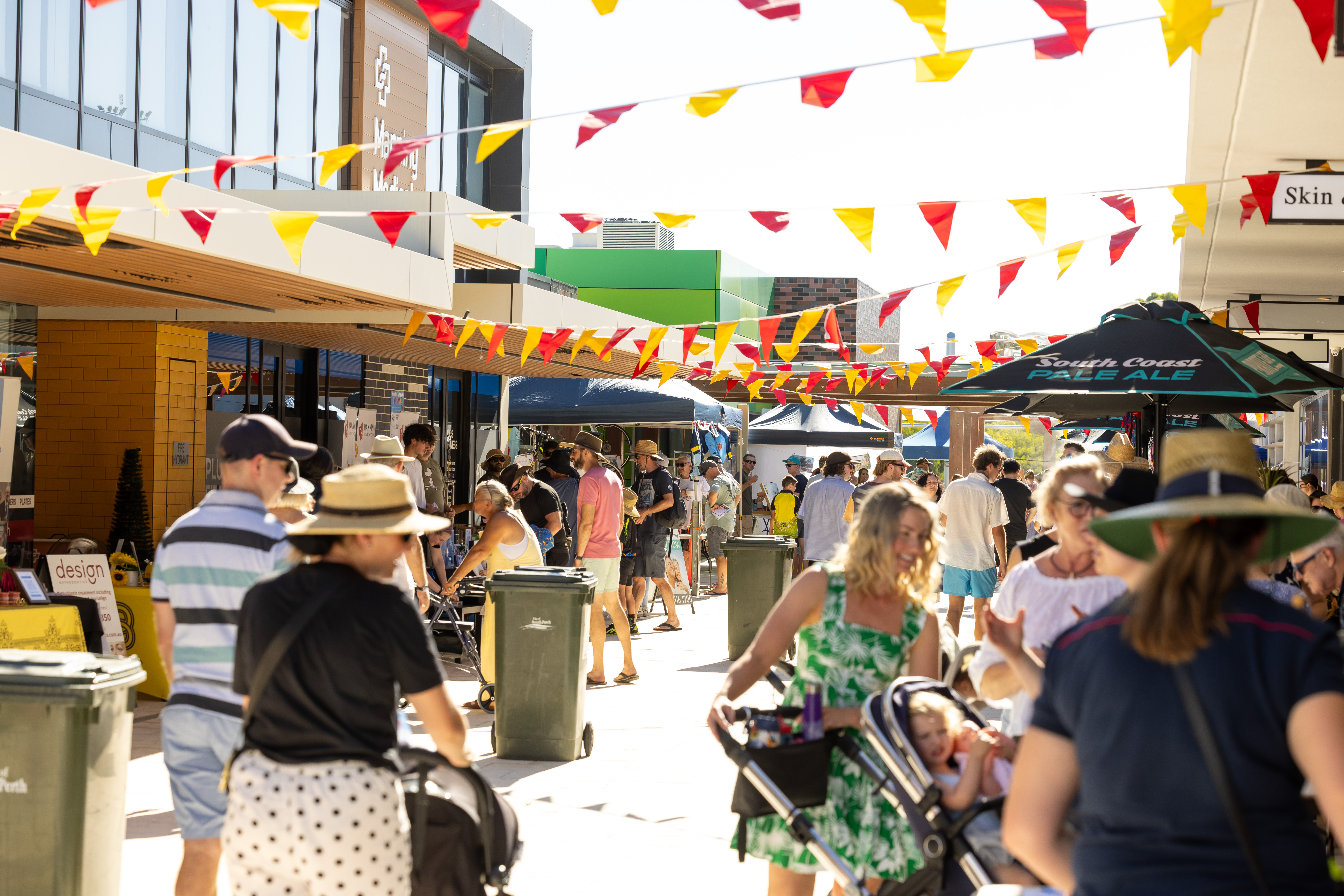 A crowd of people walking down a Laneway and browsing stalls.