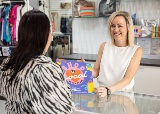 PersonhandsShopLocalSouthPerthstickertocustomerinclothingstore