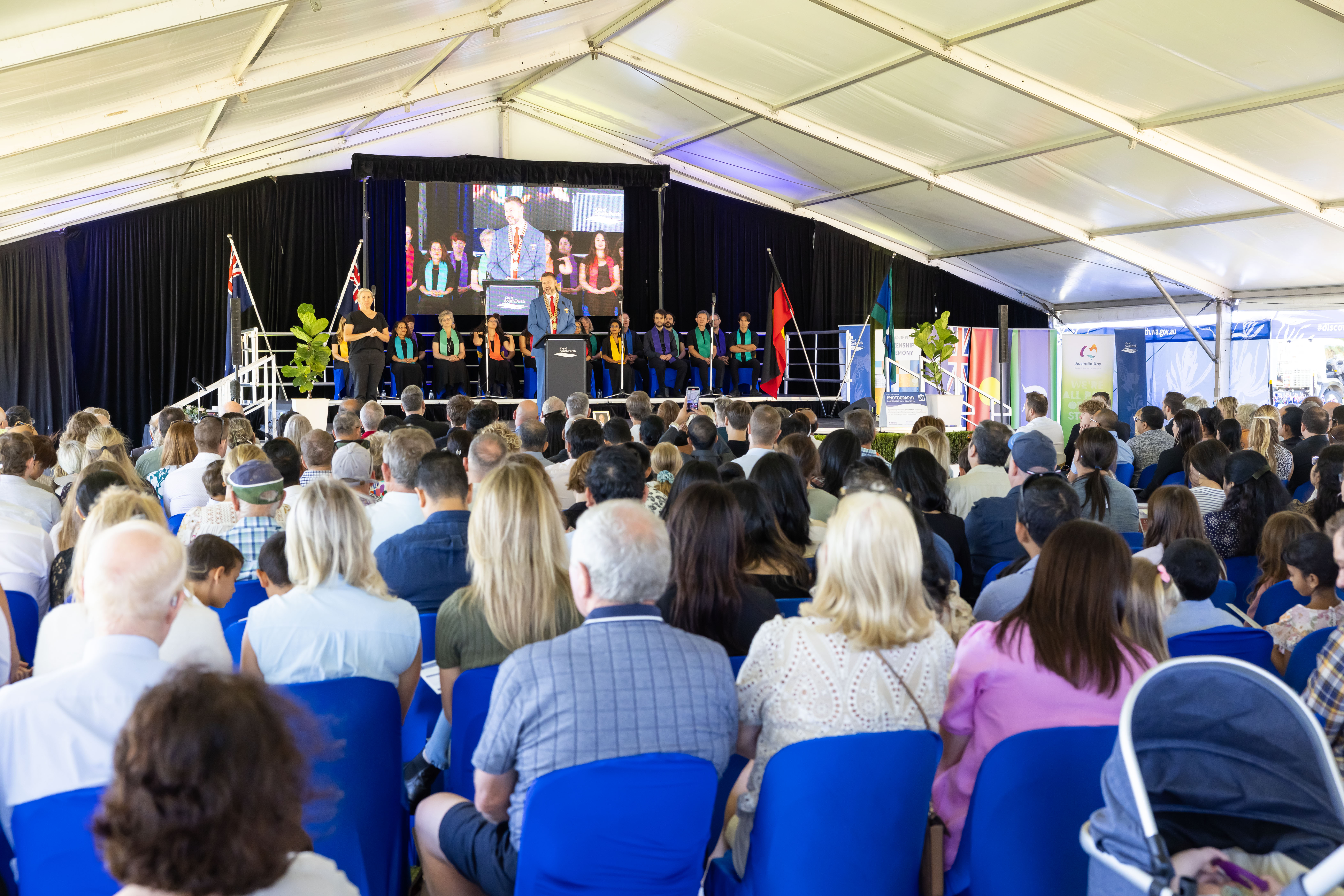 A crowd watching someone speak on stage.