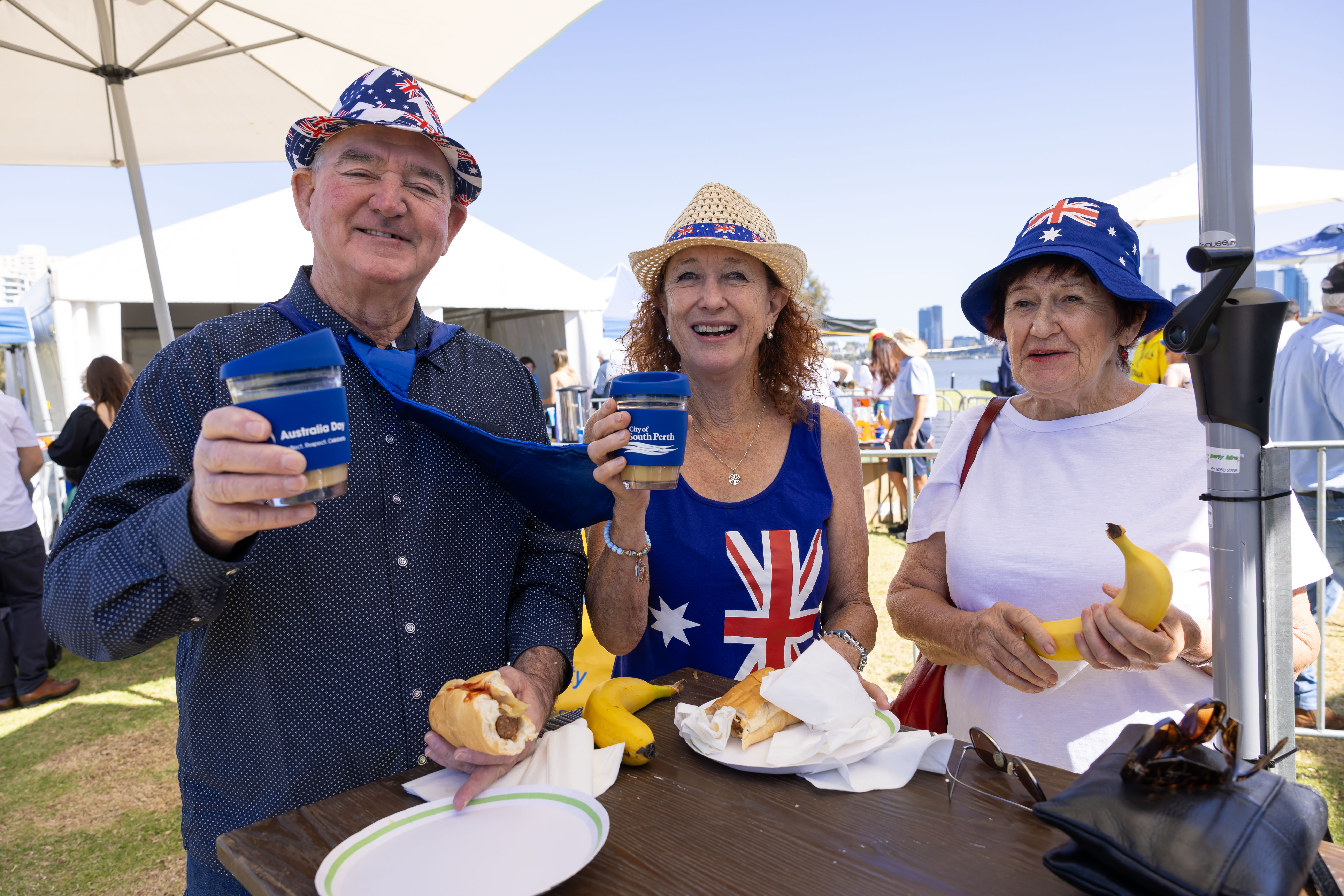 Three people eating breakfast and smiling.