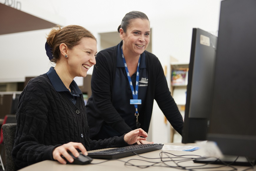 Alibrarianassistingacustomeronacomputeratthelibrary