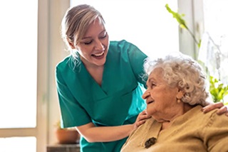 Ayoungerpersonsmilingandtoughingtheshouldersofanolderperson