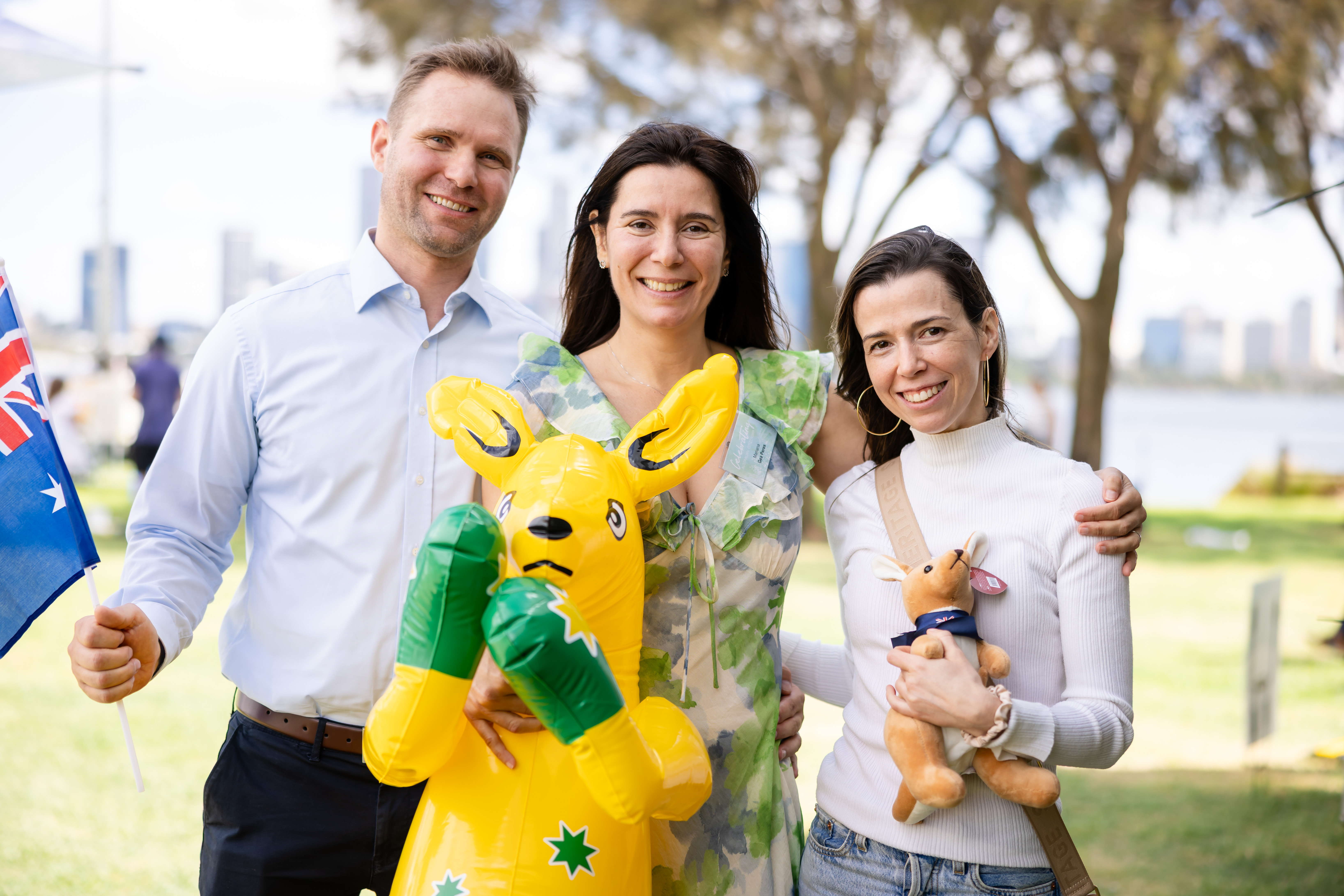 Three people smiling at camera with Australia Day merchandise