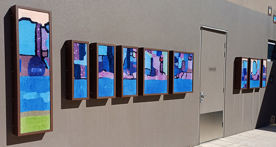 Colourful artworks displayed along a wall.