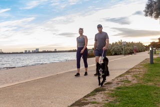 Manandwomanwalkingblackandwhitedogonforeshore