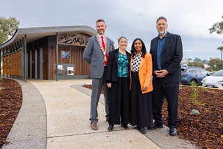Fourpeoplestandinginfrontoftoiletblockandsmiling