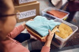 Womanholdingclothesandputtingthemintoboxesforcharitydonation