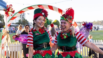 Twowomeninfestiveelfcostumessmilingatthecamera