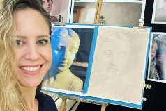 woman smiling with portrait artwork behind her.