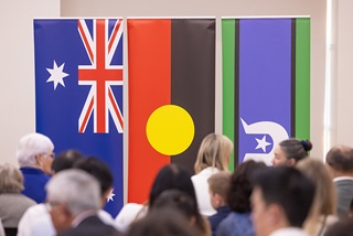 AcrowdinfrontoftheAustralianAboriginalandTorresStraitIslanderflags