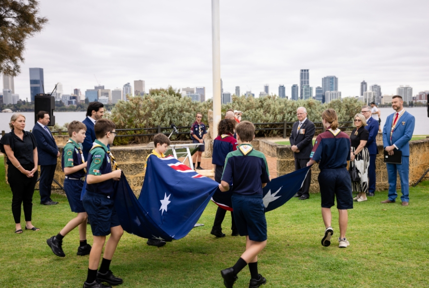 A group of children raising the Australian flag at the 2025  Citizenship ceremony