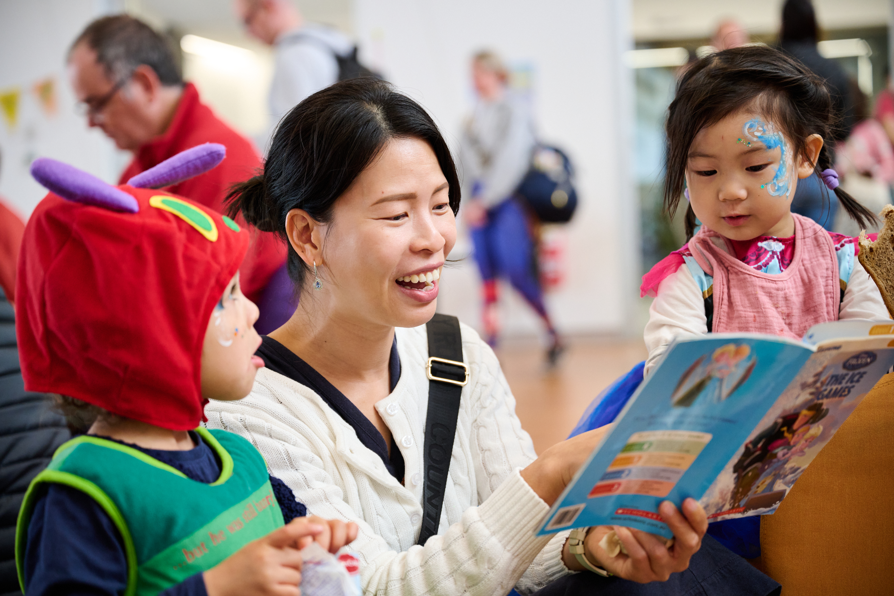 Woman reading book to children